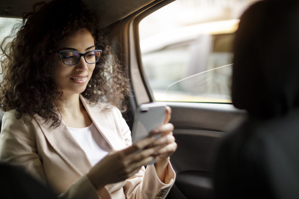 businesswoman using smart phone in a car